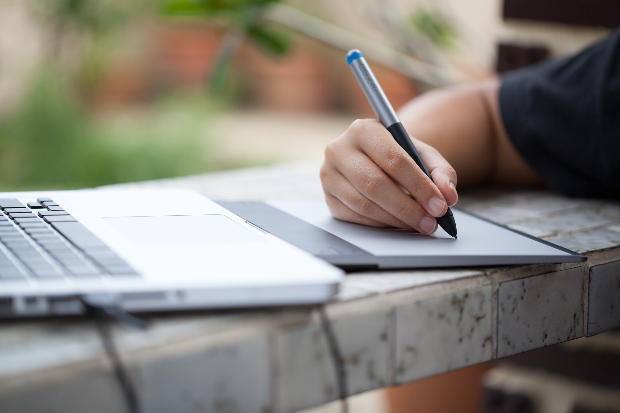 Graphic designer using digital tablet and computer at home office
