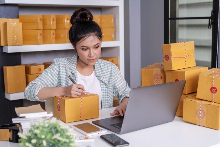 small-online-business-owner-woman-working-with-laptop-prepare-parcel-boxes-deliver-customer